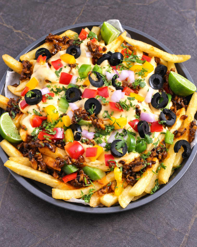 Loaded Supreme Fries with cheese sauce, chicken, vegetables, black olives, herbs, and lime.