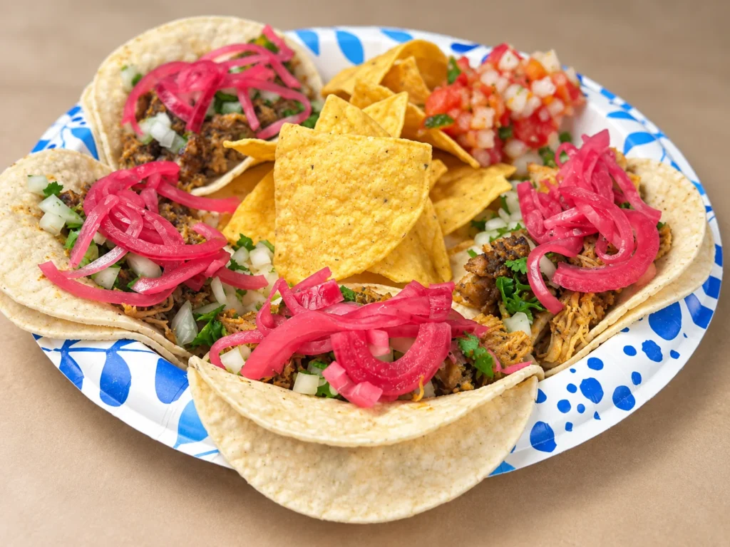Mambo Taco street tacos topped with pickled red onions and served with tortilla chips.